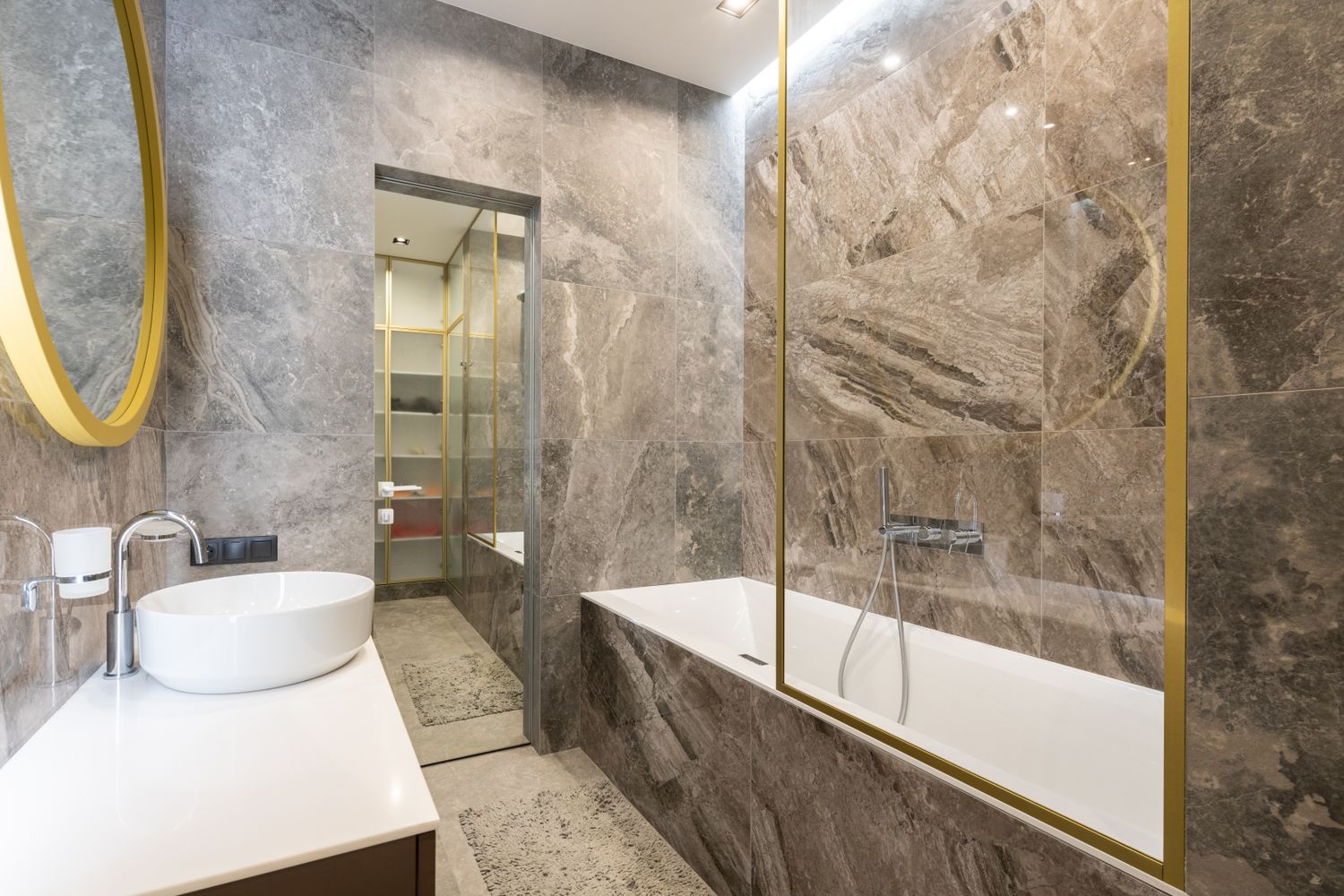Residential bathroom plumbing A modern tiled bathroom with a basin, bath and chrome fittings